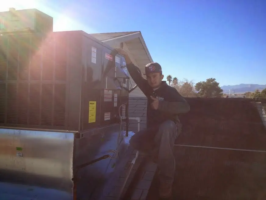 HVAC technician performing Heat Pump Repair on a rooftop unit in Mead